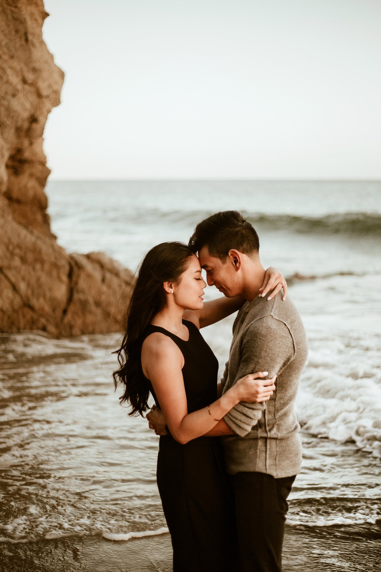 A couple forehead to forehead at the shoreline