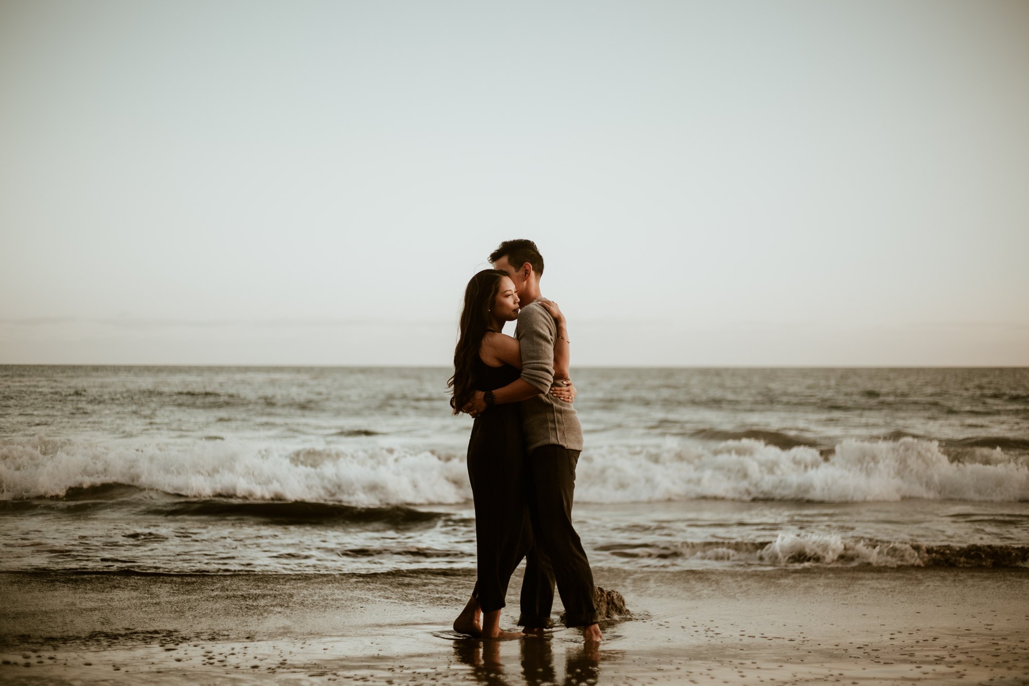 A couple dancing where the waves meet the sand