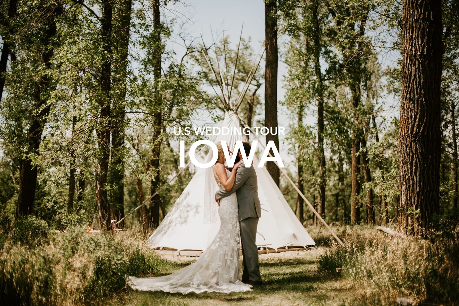 Wedding couple kissing and a tent in the background