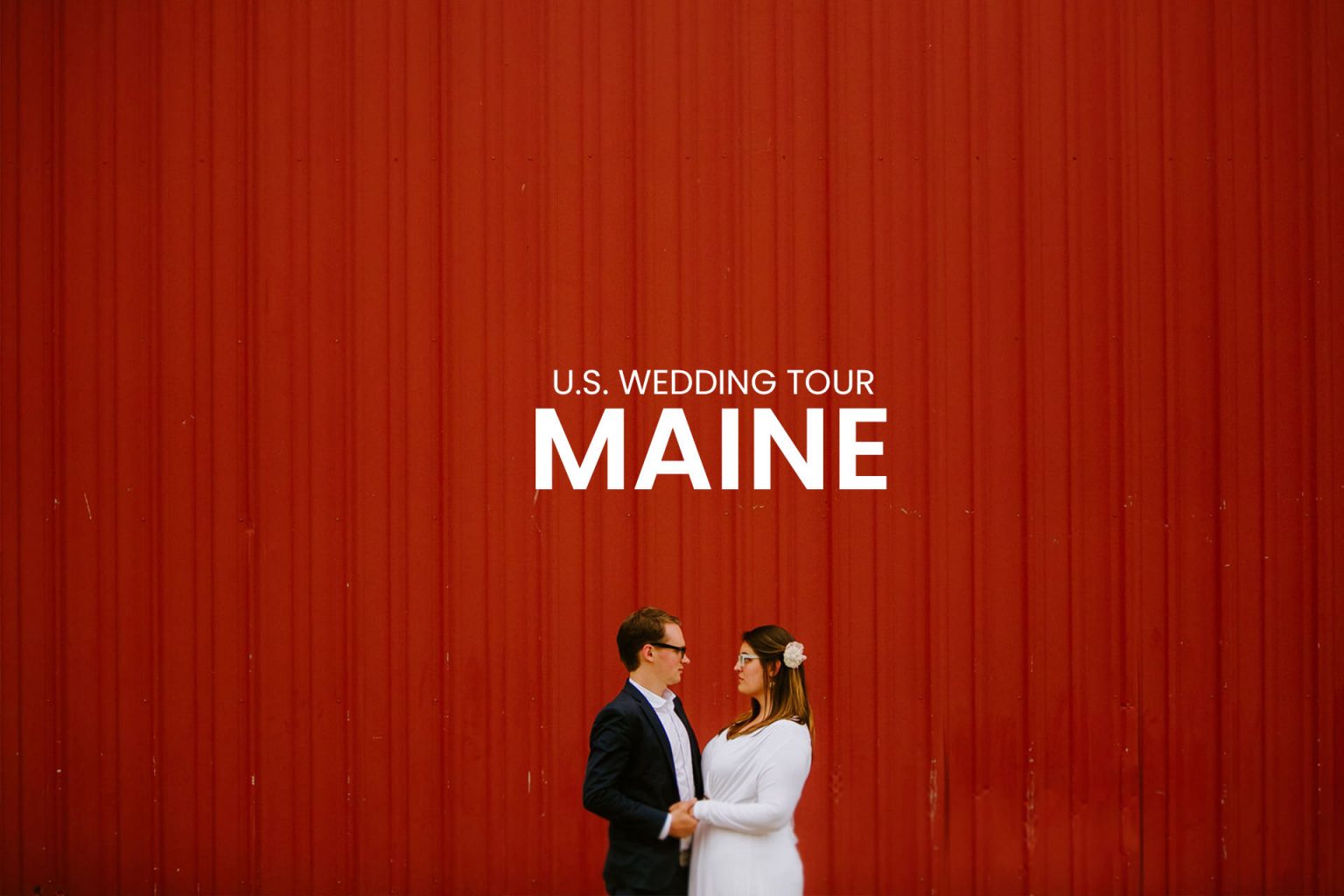 Wedding couple looking at each other against a backdrop of a red barn